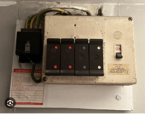 One older Wylex fuse box containing four visible fuse holders